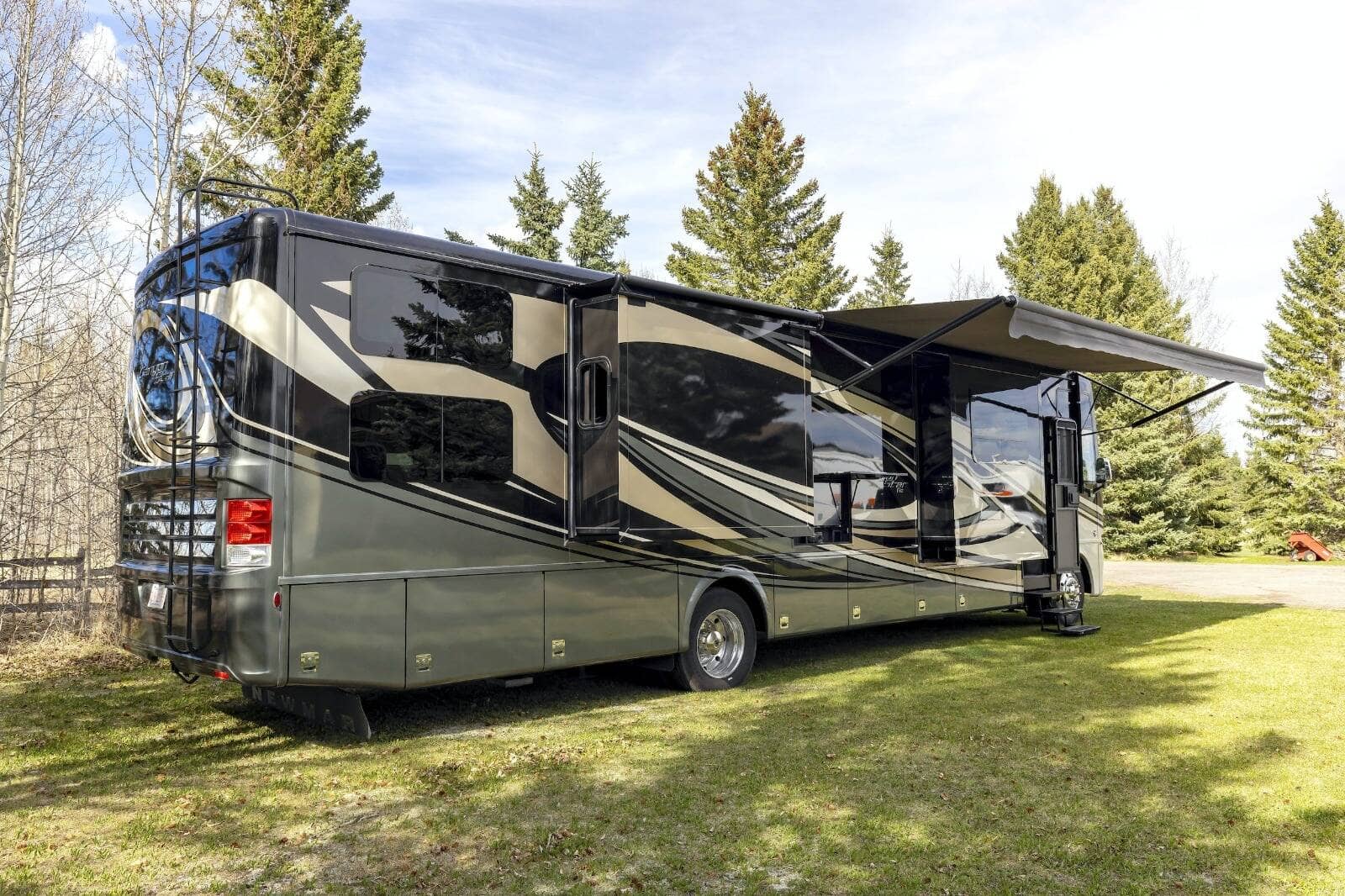 An RV parked at a campsite with its slide-out room extended.