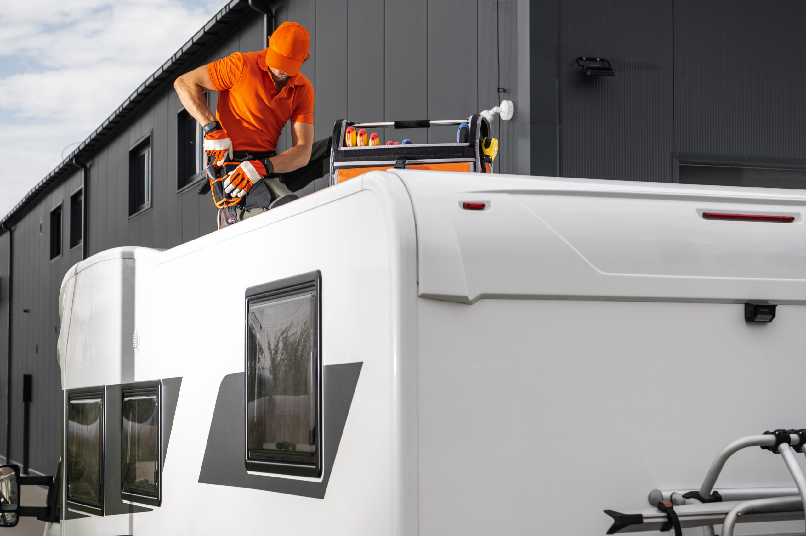 Worker Installing Equipment On A White Camper